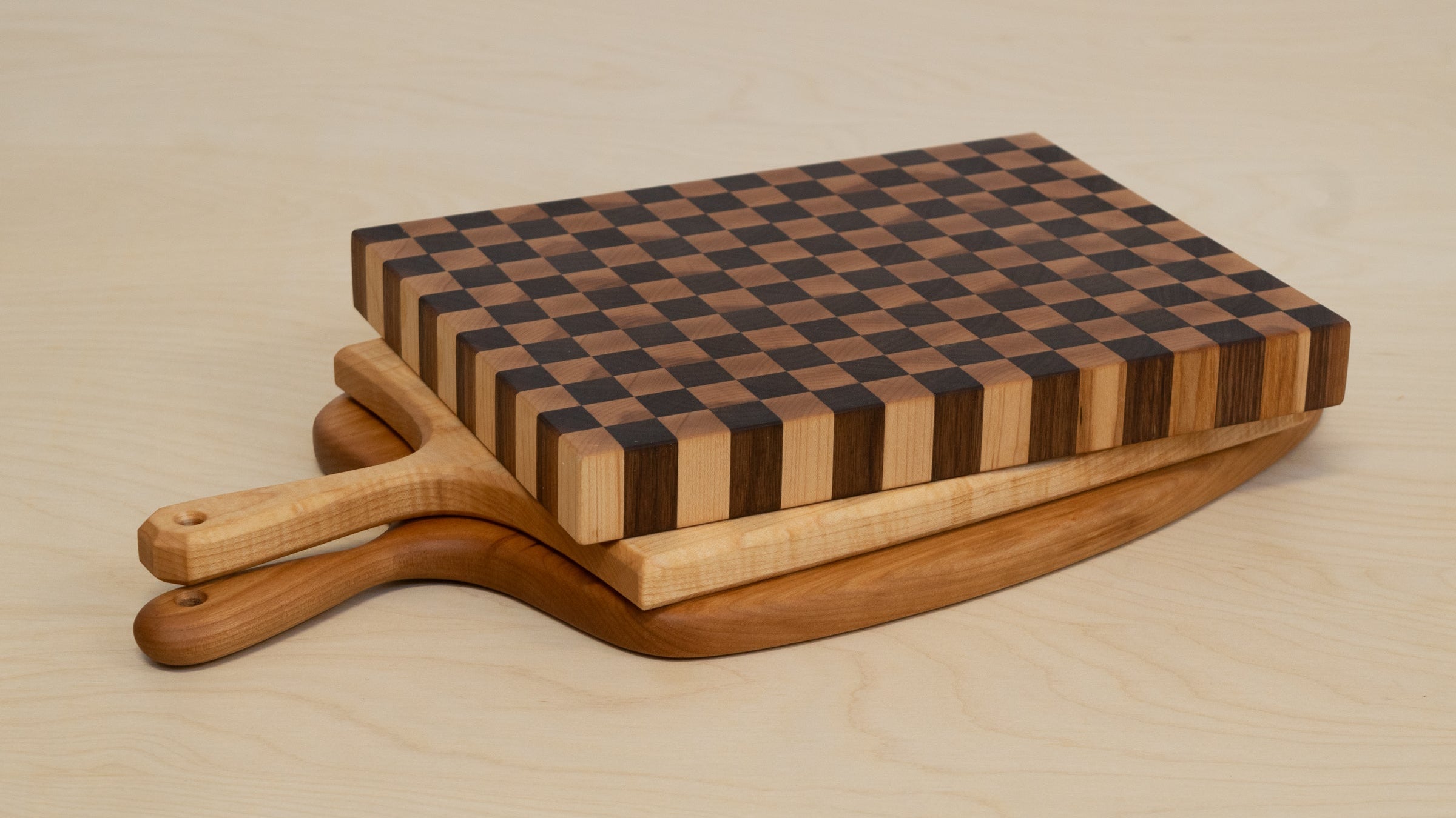 Wooden cutting board with checkered pattern on a beige surface