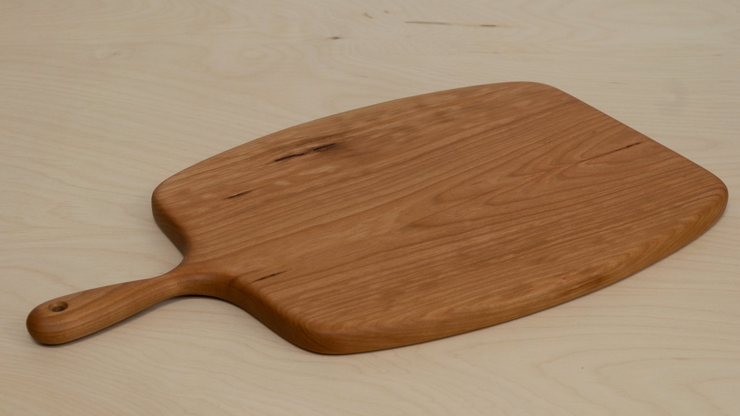 Rounded cutting board on a light wooden surface