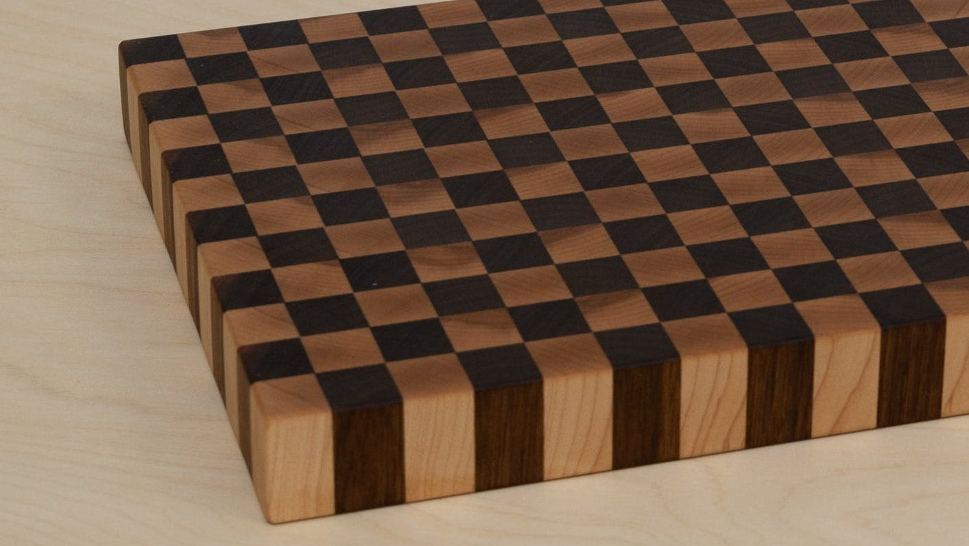 Wooden checkered cutting board on a light wooden surface