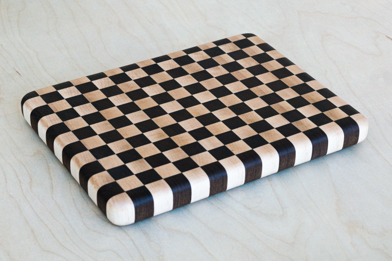Checkered cutting board on a light wooden surface